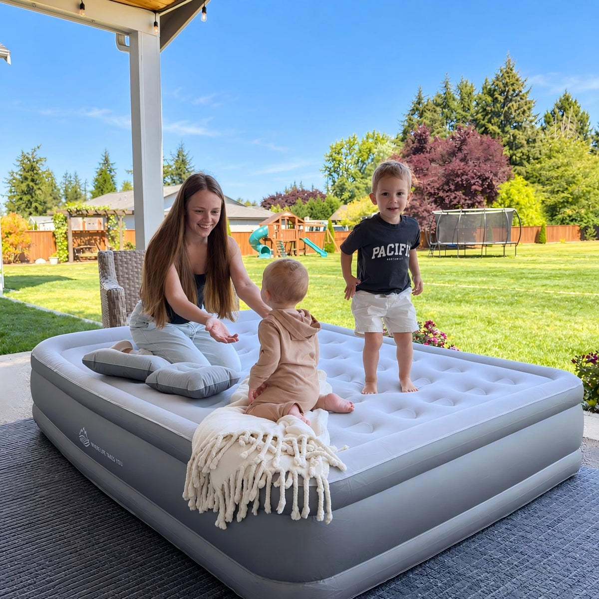 Mother and two children enjoying a JUITOY air mattress in a sunny backyard