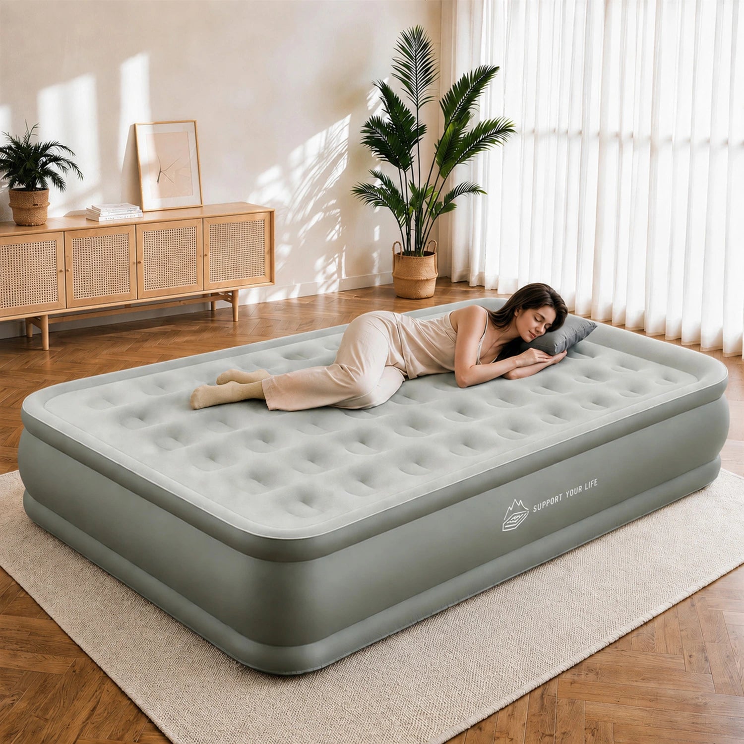 Person resting comfortably on a JUITOY Queen air mattress in a warm room
